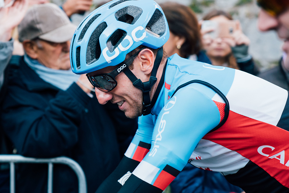 Woods with helmet and glasses on smiling on bike