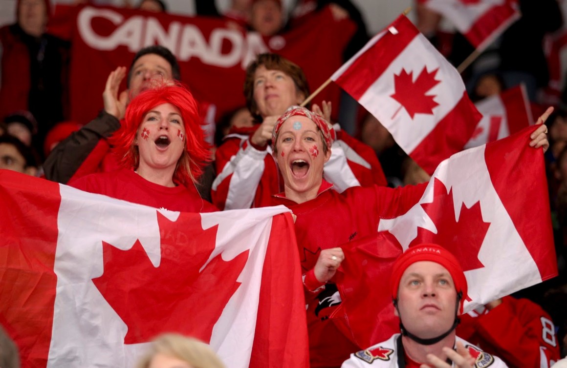 Two fans with Canadian flags cheering