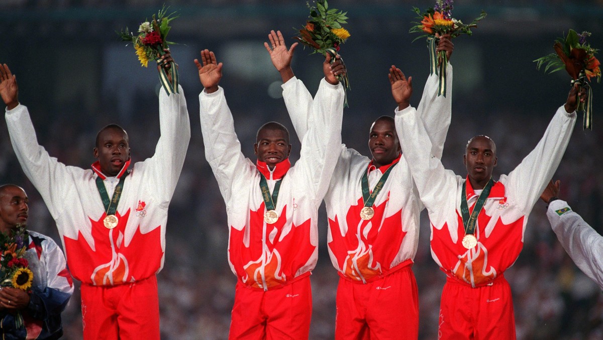 Donovan Bailey, Bruny Surin, Glenroy Gilbert and Robert Esmie raise their hands as they celebrate gold.