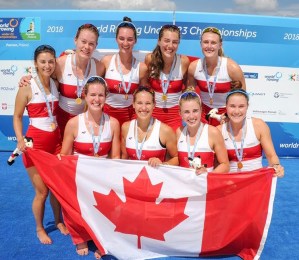 Group of Canadian rowers holding a Canadian flag