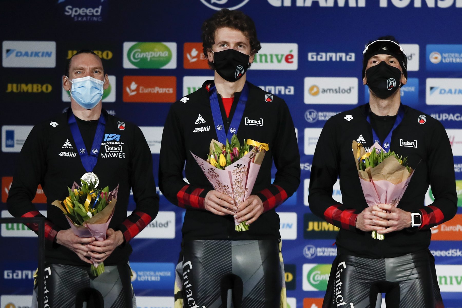 Team Canada with Ted-Jan Bloemen, left, Jordan Belchos, right, and Connor Howe, center, celebrates with their silver medals on the podium of the men's team pursuit race of the World Championships Speedskating Single Distance at the Thialf ice arena in Heerenveen, northern Netherlands, Friday, Feb. 12, 2021. (AP Photo/Peter Dejong)