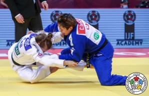 Christa Deguchi (in blue) takes down Serbia's Marica Perisic during a judo match.