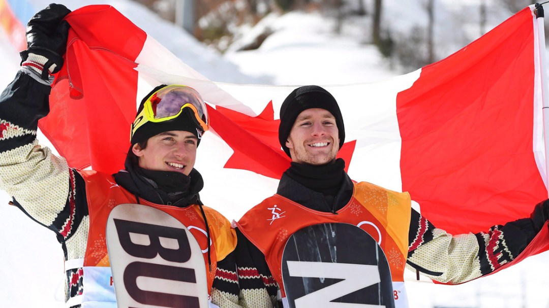 Mark McMorris (lef) holds up the Canadian flag behind him with Max Parrot.