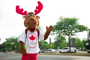 Team Canada's mascot, Komak the moose, is waving with a backpack on