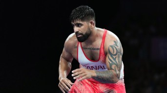 Amar Dhesi in a ready stance while wearing a white Team Canada singlet