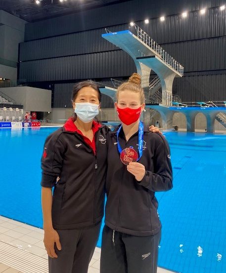 Diver and her coach pose with bronze medal