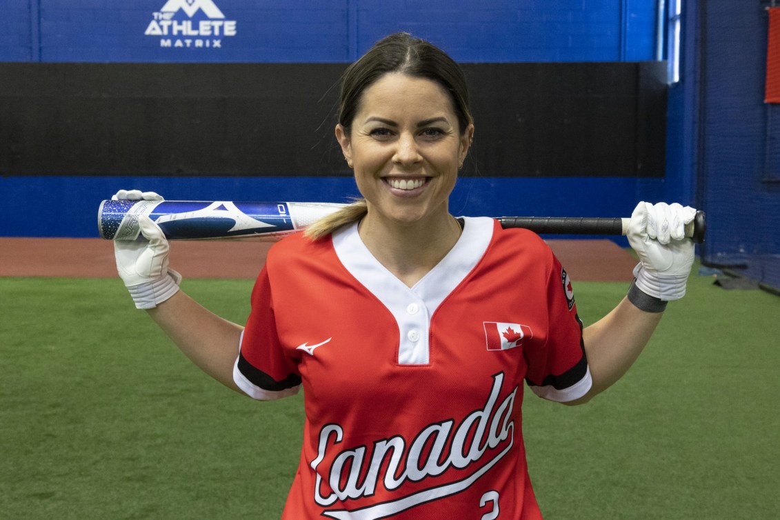 Natalie Wideman holds bat on shoulders while posing for camera