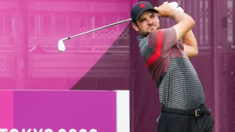 Corey Conners holds his club behind his head after a swing