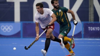 Field hockey player running with ball on his stick