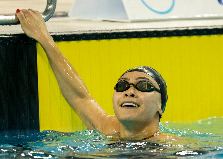 swimmer smiles in pool after winning race