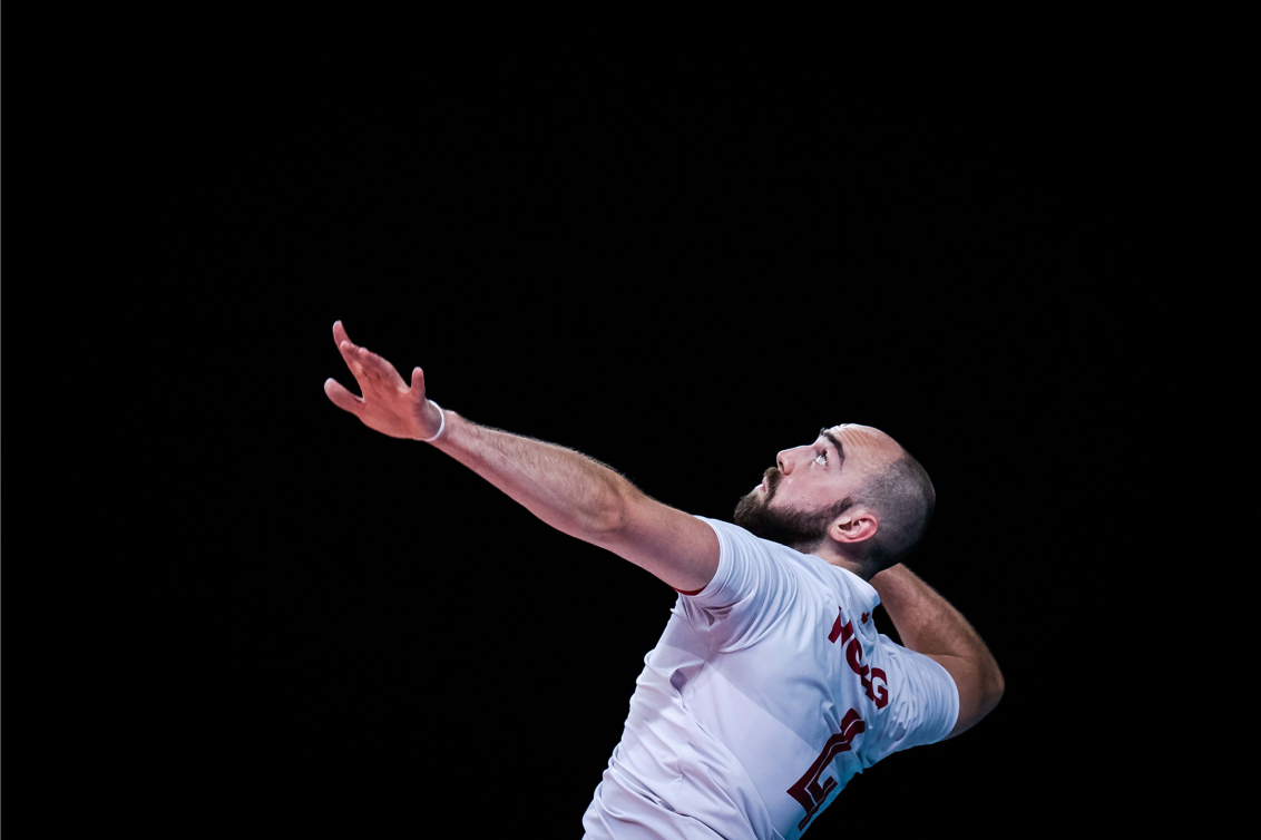 Nick Hoag spikes ball during an indoor volleyball match