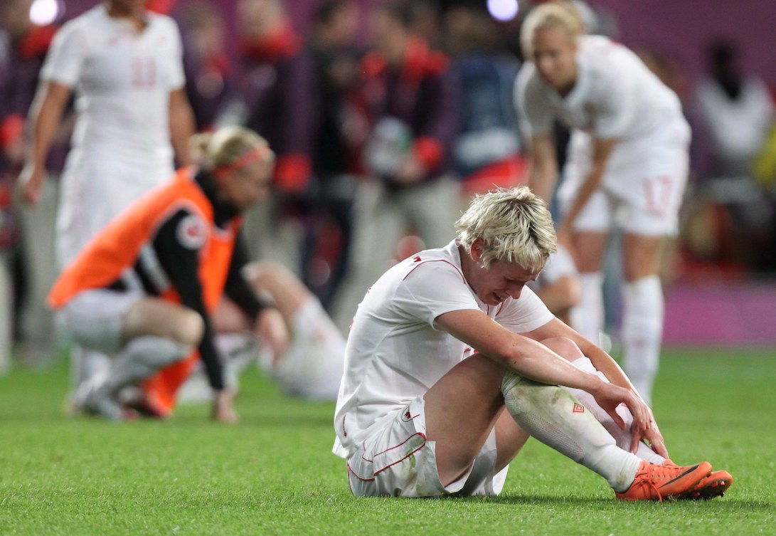 Sophie Schmidt sits on the field crying after Canada's loss to the USA at London 2012
