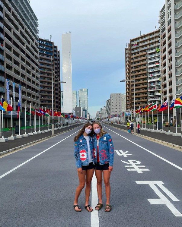 Two female athletes standing in the middle of flag street for a picture