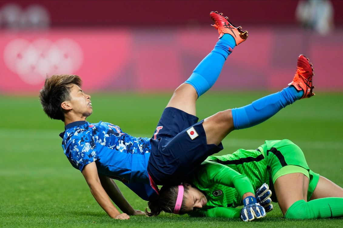 Japan's Mina Tanaka falls on top of Canadian goalkeeper Stephanie Labbe's head following a collision.
