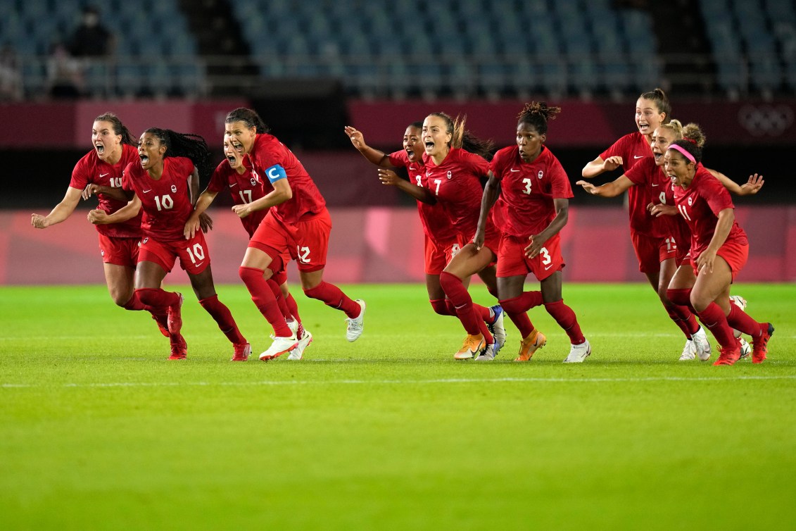 Canadian players react with excitement after winning the penalty shootout against Brazil