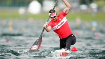 Connor Fitzpatrick races his canoe while wearing Team Canada gear