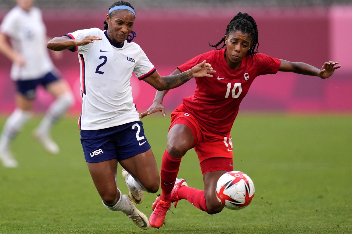 Ashley Lawrence and Crystal Dunn fight for the ball