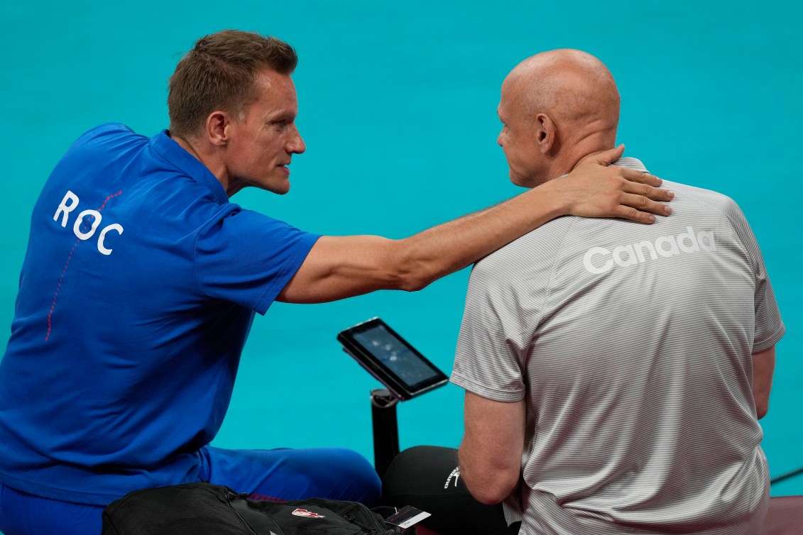 The ROC coach comforts the Canada coach after the match.