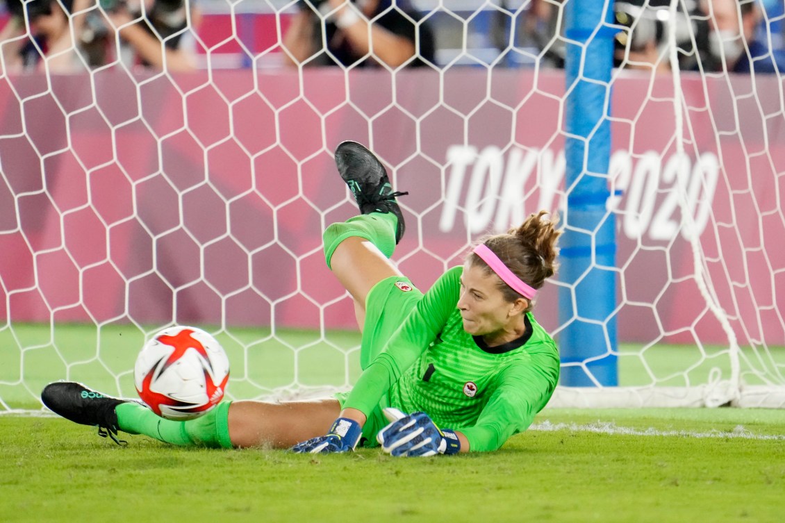 Stephanie Labbe dives to stop a penalty kick