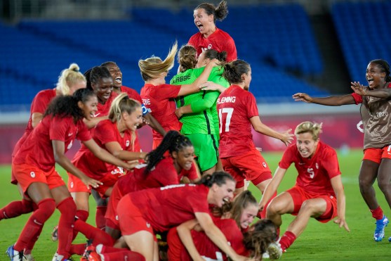 Team Canada celebrates on the field following the win