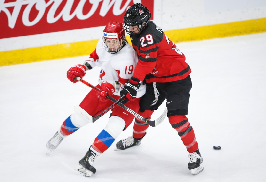 Russia's Yelena Provorova, left, is is checked by Canada's Marie-Philip Poulin during first period IIHF Women's World Championship hockey action in Calgary, Alta., Sunday, Aug. 22, 2021. THE CANADIAN PRESS/Jeff McIntosh
