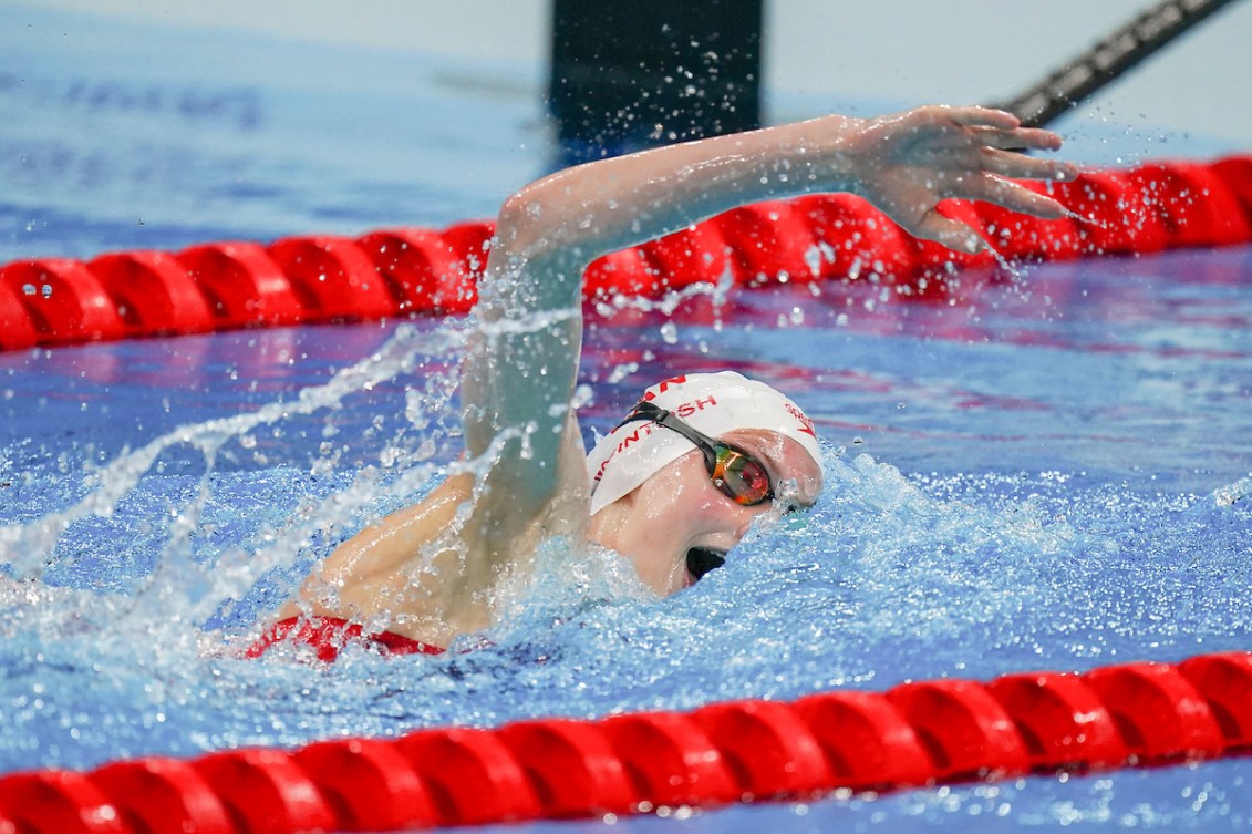 Summer McIntosh, wearing a swim cap and goggles, swims in the Olympic pool