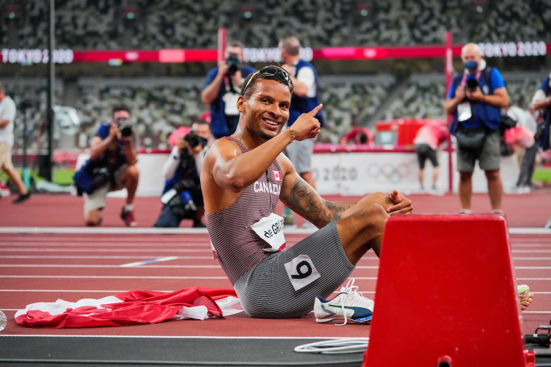 Andre De Grasse poses for the camera at the finish line