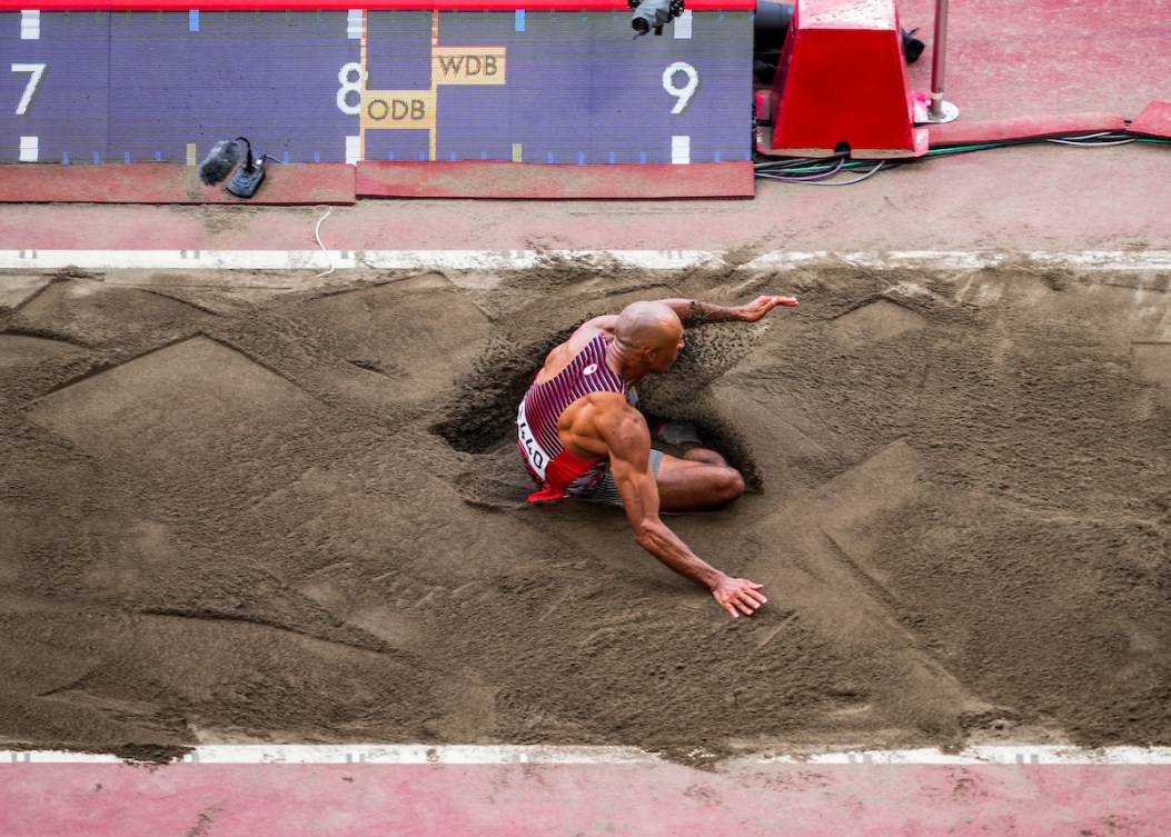 Overhead shot of Warner landing long jump in sand pit