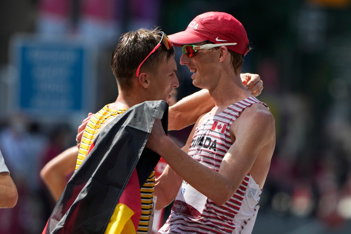 Evan Dunfee celebrates with Jonathan Hilbert of Germany.