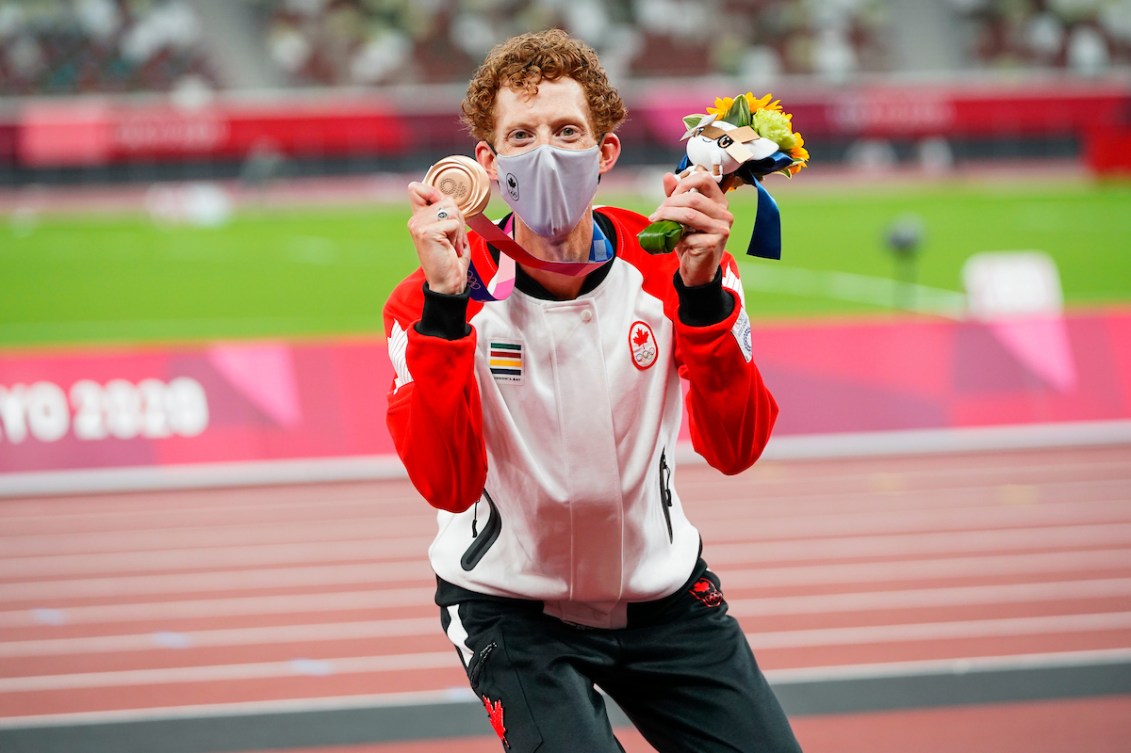 Evan Dunfee celebrates Olympic bronze on the podium.