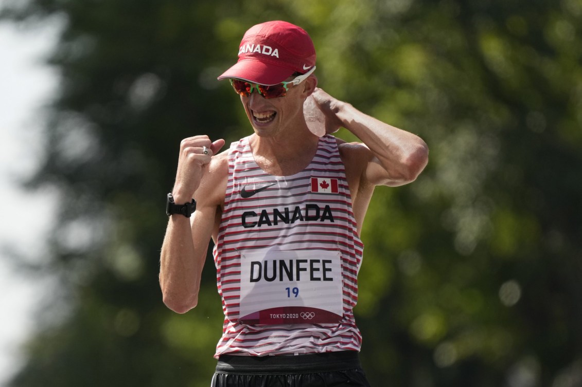 Evan Dunfee pumps his fist in celebration as he wins bronze in the 50km race walk