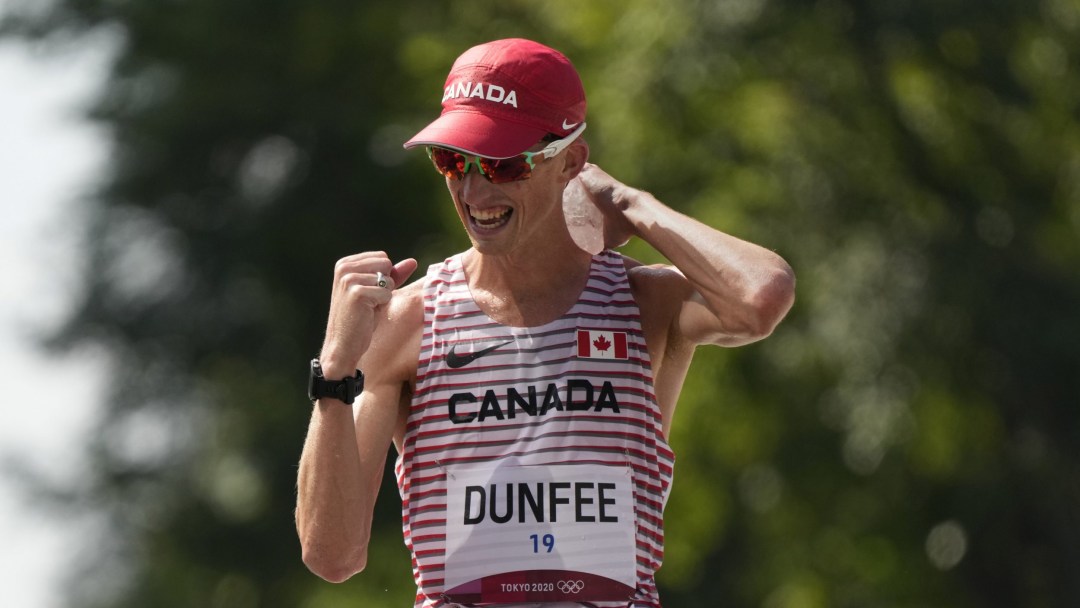 Evan Dunfee pumps his fist in celebration as he wins bronze in the 50km race walk