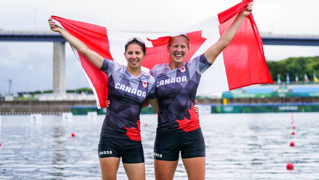 Laurence Vincent Lapointe and Katie Vincent pose with the Canadian flag