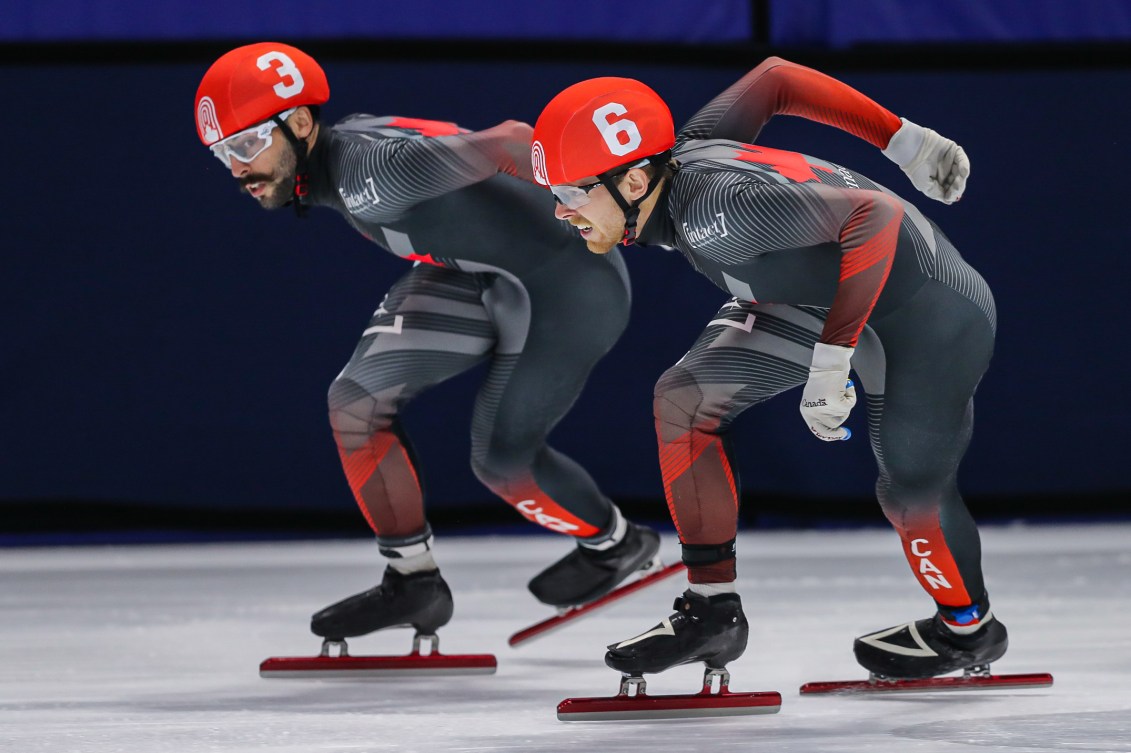 Side shot of two short track speed skaters in a race 