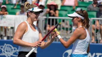 Gabriela Dabrowski (left) chats with doubles parter Luisa Stefani as they exchange tennis balls.