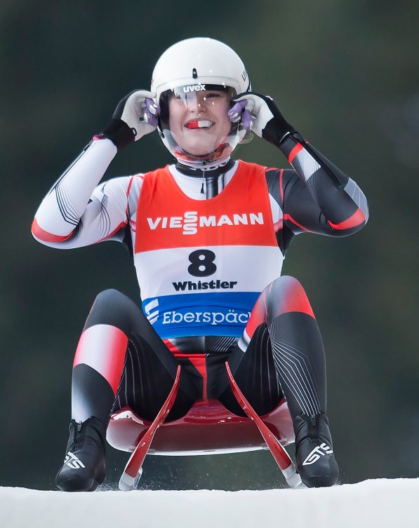 Makena Hodgson sits up on her sled after crossing the finish line 