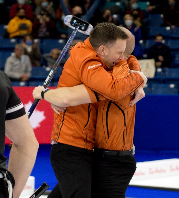 Brad Gushue and Mark Nichols hug on the ice 