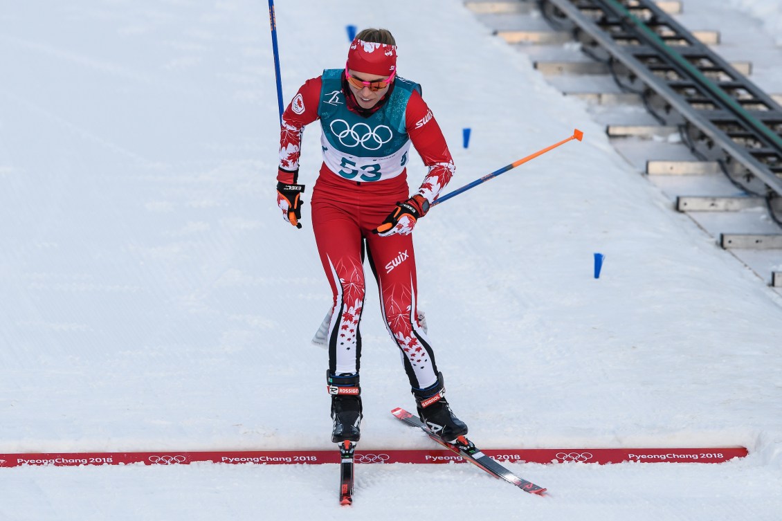 Cross country skier crosses finish line in a race 