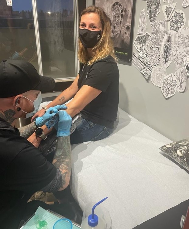 Catriona Le May Doan getting a tattoo inked on her arm