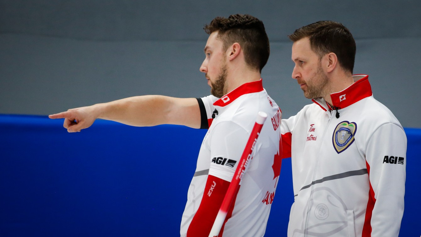 Le capitaine d'Équipe Canada, Brad Gushue, à droite, et son deuxième Brett Gallant discute de stratégie lors d'un match contre Équipe Saskatchewan au Brier à Calgary en Alberta, le lundi 8 mars 2021.