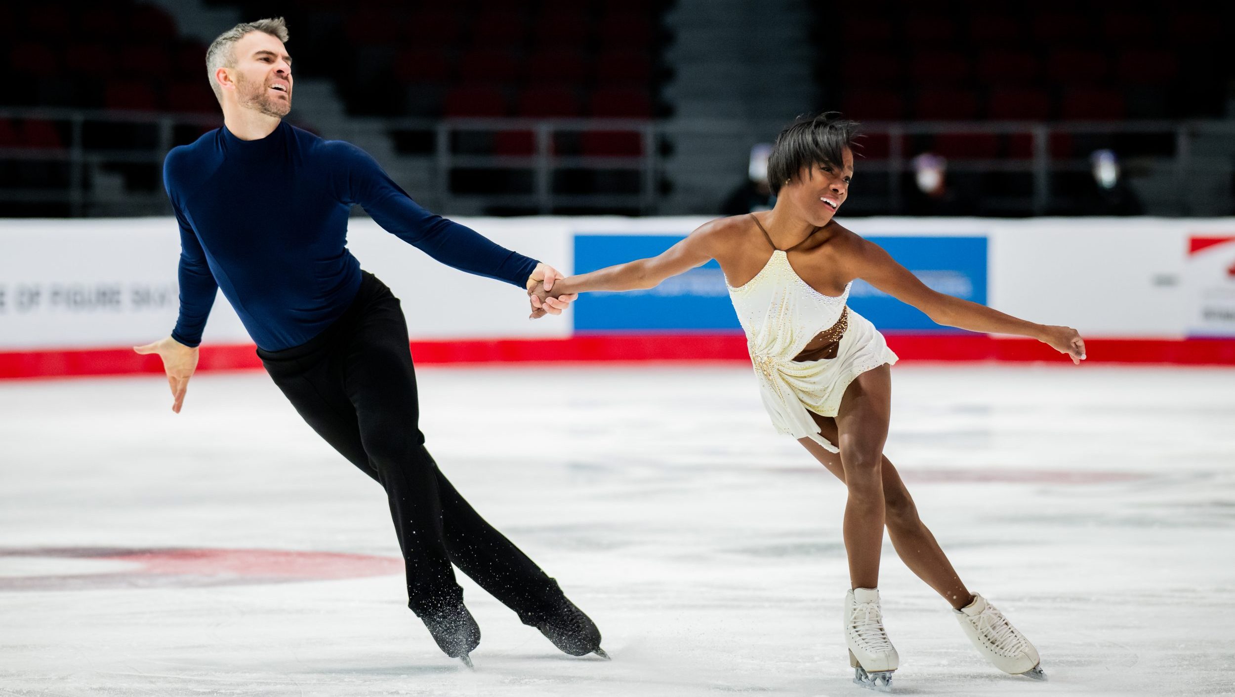 Vanessa James and Eric Radford hold hands while skating
