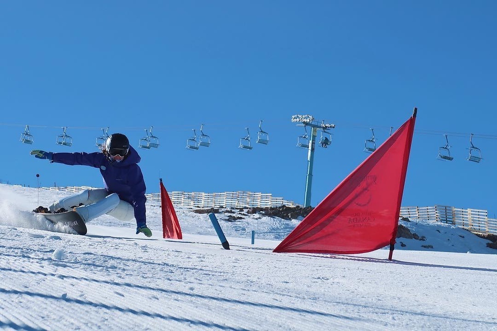 Megan Farrell snowboards around a gate on a course