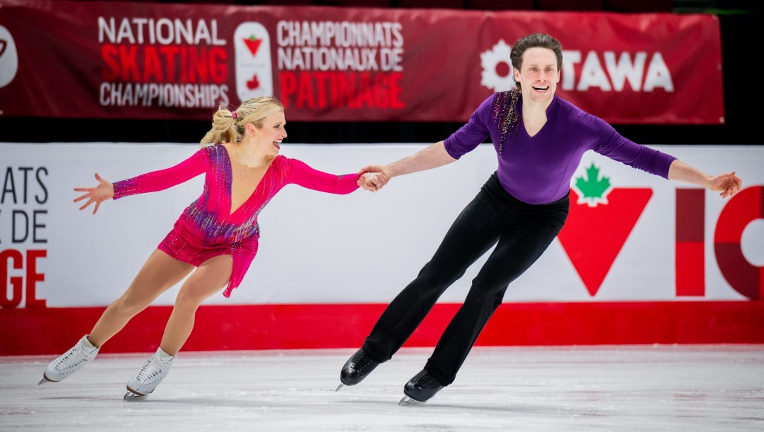 Kirsten Moore-Towers and Michael Marinso hold hands while skating