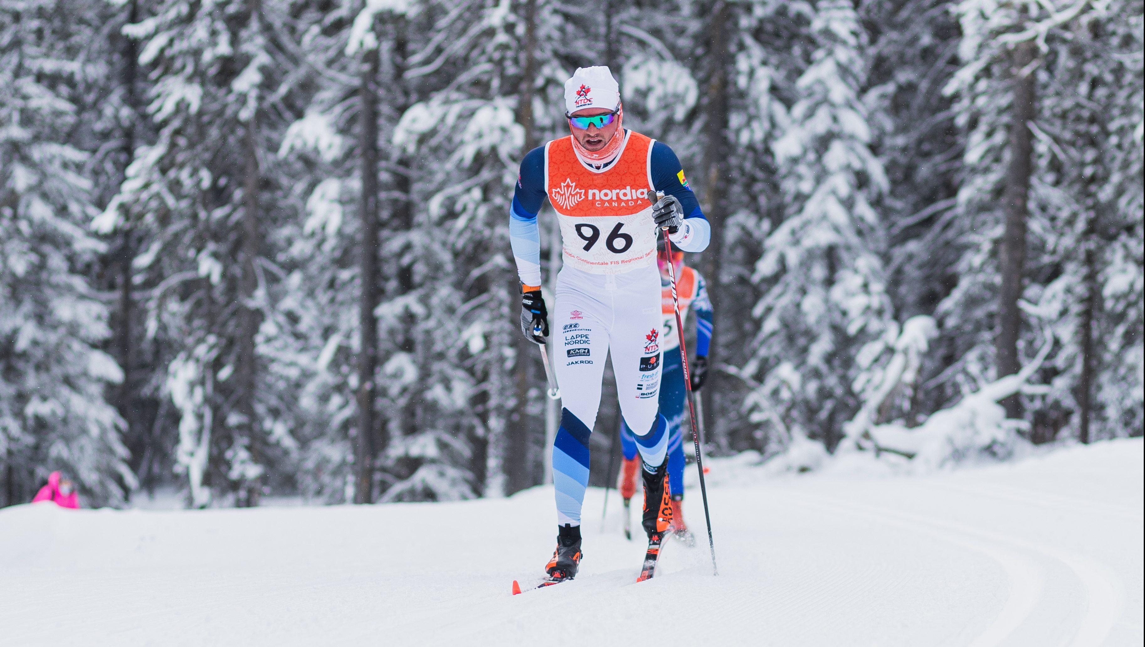 Male athlete is skiing during a cross country race.