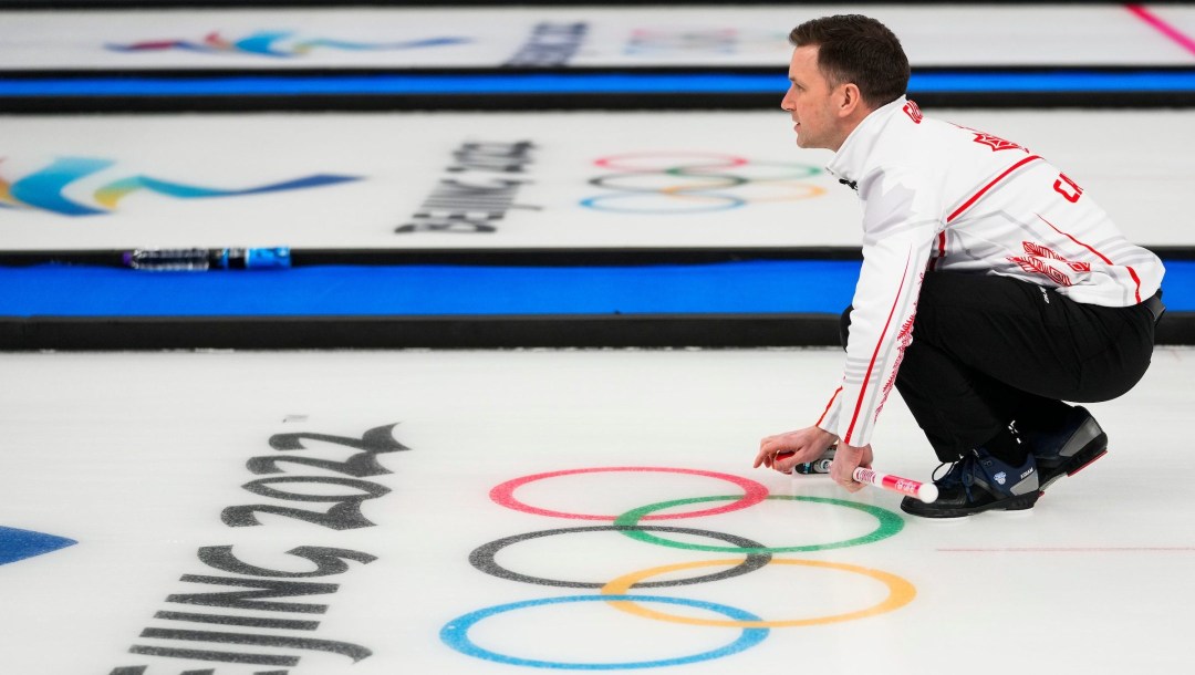 Brad Gushue watches his stone travel down the ice