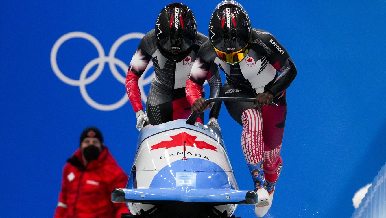 Cynthia Appiah and Dawn Richardson Wilson , of Canada, start the women's bobsleigh heat 3 at the 2022 Winter Olympics, Saturday, Feb. 19, 2022, in the Yanqing district of Beijing. (AP Photo/Dmitri Lovetsky)