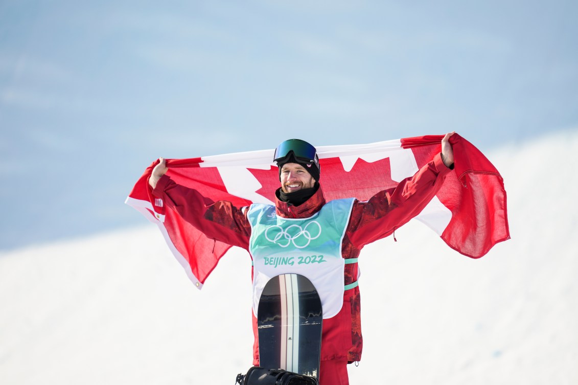 Max Parrot holds the Canadian flag behind him on the podium