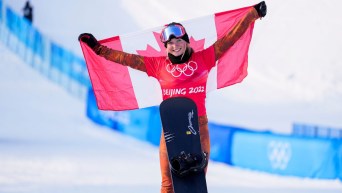Meryeta O'Dine holds Canadian flag on the podium