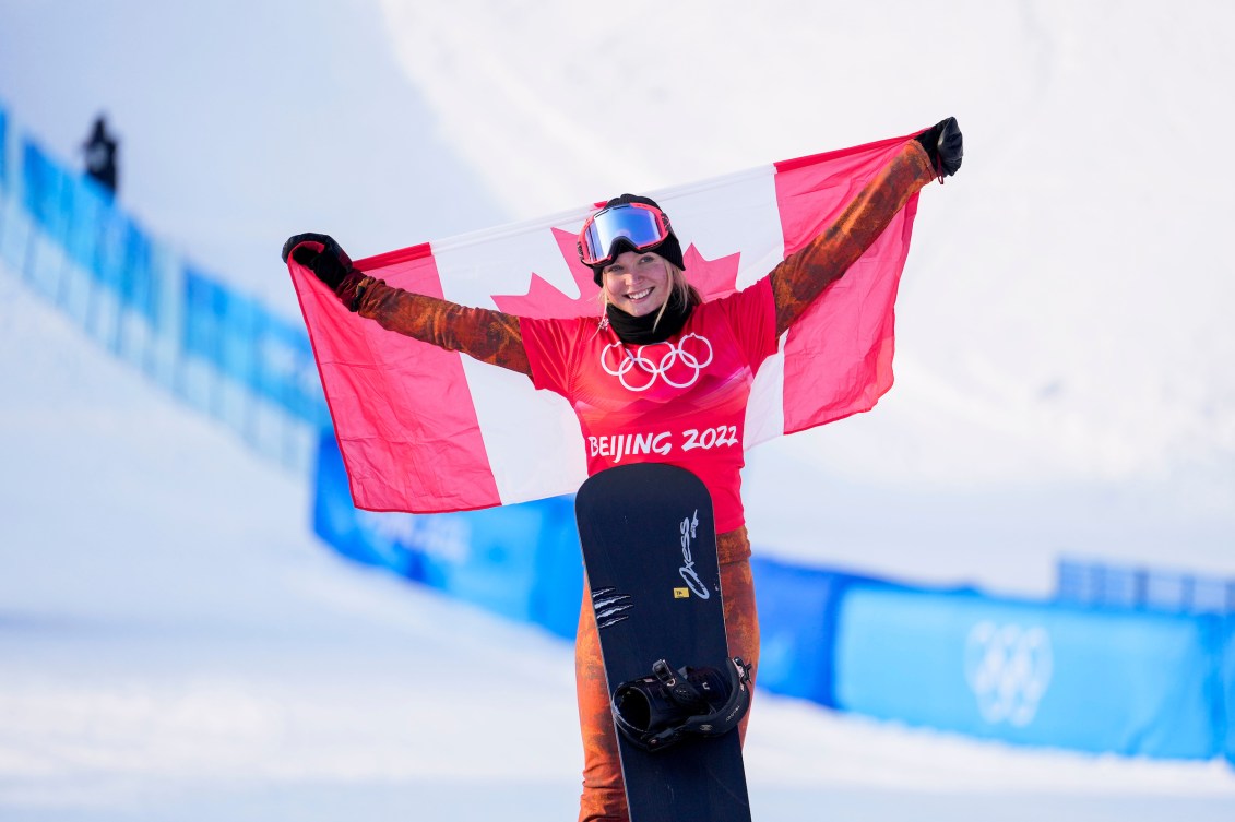 Meryeta O'Dine holds Canadian flag on the podium