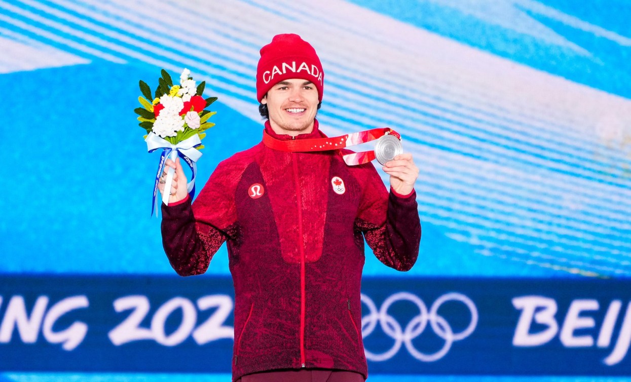 Mikael Kingsbury holds up his silver medal at Beijing 2022